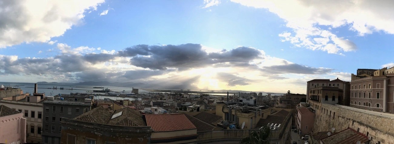 Vaccine in a bottle banner image -Panoramic photo of the coastal town of Cagliari